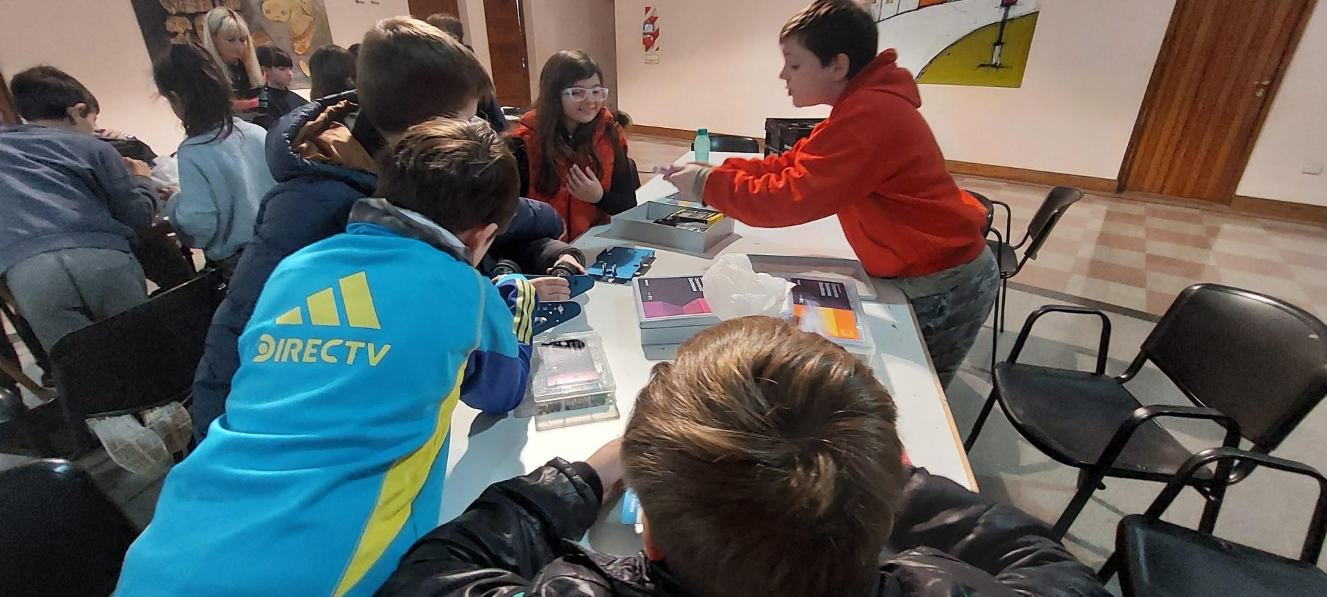 Fotografía de estudiantes en un aula trabajando en una mesa