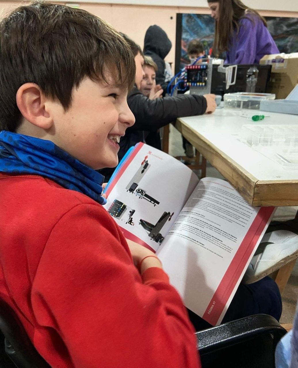 Un estudiante riendose con un libro en la mano