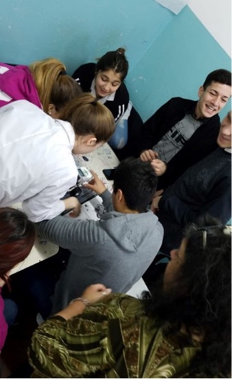 Estudiantes trabajando con un robot sobre una mesa