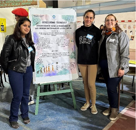 3 personas posando para la foto, junto a un poster