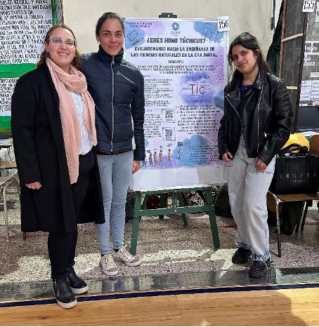3 personas posando para la foto, junto a un poster