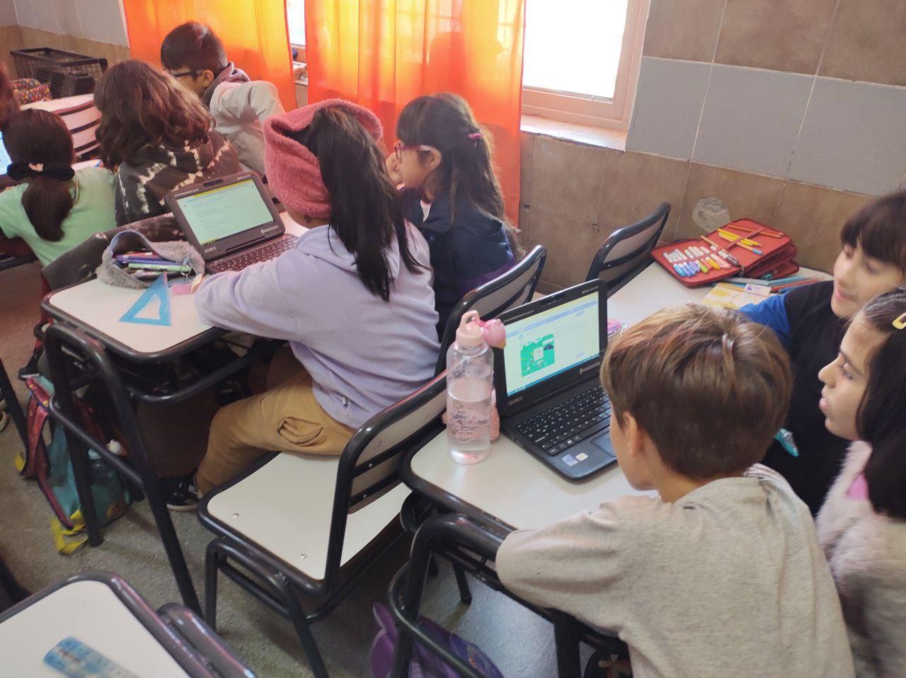 Fotografía de estudiantes trabajando con computadoras en un aula