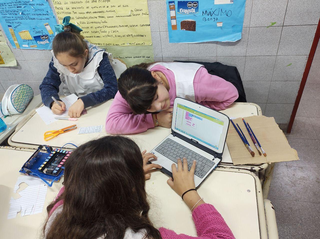 Fotografía de estudiantes trabajando con una computadora en un aula